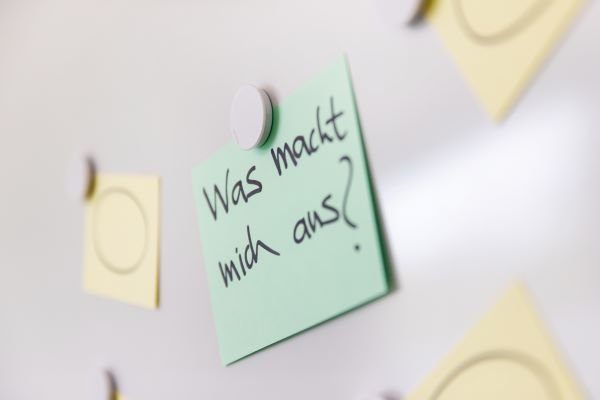 Haftnotiz mit der Frage: Was macht mich aus?
